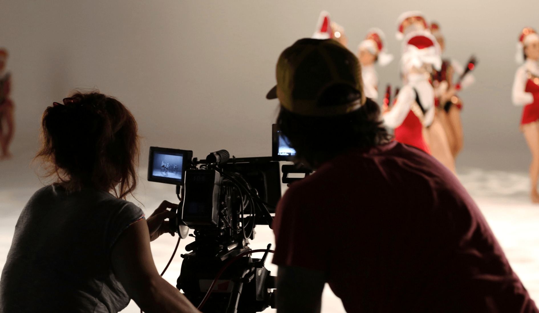 Crew filming dancers in red and white costumes on set