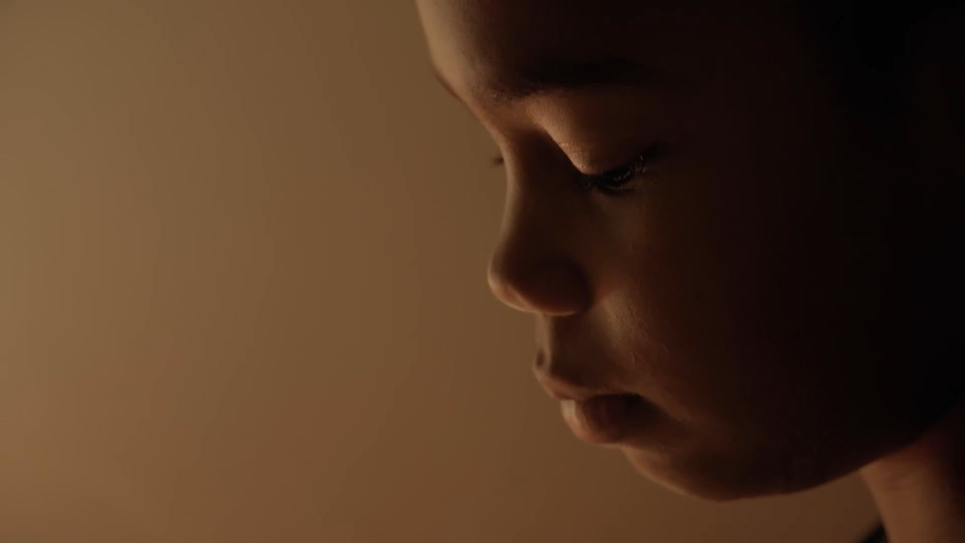 A child's face in warm, low light
